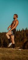 An athlete rests on top of a mountain after exhausting running training. photo