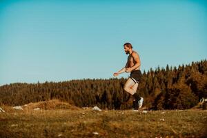 An athlete rests on top of a mountain after exhausting running training. photo