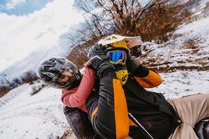 Couple enjoying while driving quad bike on top of mountain at winter time photo