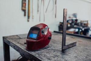 Welding helmet and measuring device on a table in an industrial factory photo
