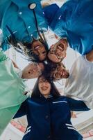 Group of doctors a medical nurse, and a surgeon are captured in a heartfelt embrace, showcasing their unity, teamwork, and profound connection in the healthcare field. photo