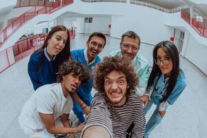 In a modern hospital hallway, a doctor and a medical nurse capture a selfie with a wheelchair patient, radiating joy, inclusivity, and the positive impact of technology in healthcare. photo