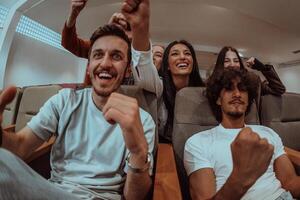 In a heartwarming scene, a diverse group of friends gathers around a television, radiating joy and unity as they collectively witness and celebrate a joyful event together. photo