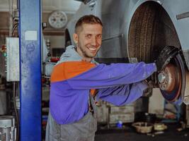 An automotive mechanic in his workshop, diligently repairing the brakes on a car with precision and expertise photo