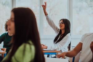 A black-haired female student wearing glasses is attentively engaged in a modern classroom, embracing education and learning with focus and curiosity photo