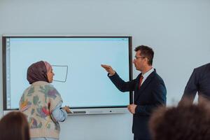 A modernly dressed professor engages in educating students, who listen attentively, creating a dynamic scene of knowledge-sharing and focused learning in the classroom. photo