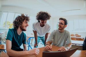A diverse studetns group, including an Afro American with an afro hairstyle communicating and engage with their colleague while seated in a modern classroom, collectively focused on a laptop. photo