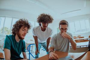 A diverse studetns group, including an Afro American with an afro hairstyle communicating and engage with their colleague while seated in a modern classroom, collectively focused on a laptop. photo