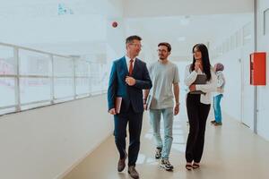 The director conducts a conversation with the secretary and a young programmer in a modern and spacious corridor of a large company, discussing various business topics and projects. photo