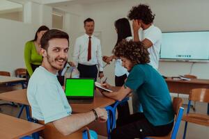 A group of business colleagues exchange knowledge and insights while utilizing laptops in the office, showcasing collaborative learning, effective communication, and a dynamic corporate environment photo