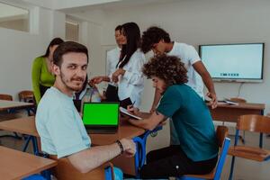 A group of business colleagues exchange knowledge and insights while utilizing laptops in the office, showcasing collaborative learning, effective communication, and a dynamic corporate environment photo