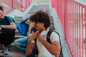 A diverse group of students sits on the steps of a modern school hallway during an educational break, sharing laughter, jokes, and knowledge, embodying a sense of unity and camaraderie. photo