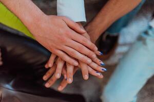 A diverse group of students symbolizes unity as they interlace their hands, portraying a sense of community, collaboration, and inclusive harmony photo
