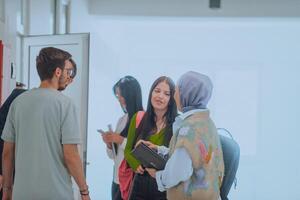 In a school hallway, a diverse group of students takes a break from their classes, engaging in lively conversations that reflect the rich tapestry of their multicultural friendships photo