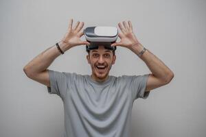 A delighted man wearing VR glasses is immersed in a virtual world, his smiling face reflecting the excitement of the digital experience photo