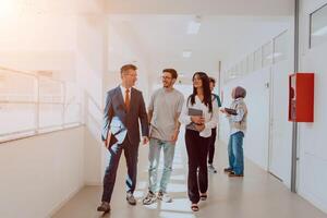 The director conducts a conversation with the secretary and a young programmer in a modern and spacious corridor of a large company, discussing various business topics and projects. photo