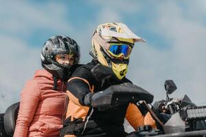 A young adventurous couple embraces the joy of love and thrill as they ride an ATV Quad through the snowy mountainous terrain photo