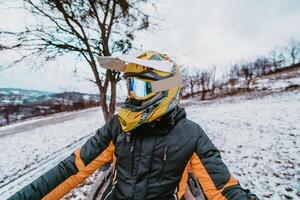 A man is fearlessly enjoying an adventurous ride on an ATV Quad through hazardous snowy terrain, embracing the thrill and excitement of the challenging mountainous landscape photo