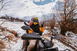 A young adventurous couple embraces the joy of love and thrill as they ride an ATV Quad through the snowy mountainous terrain photo