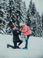 In the enchanting embrace of winter, this romantic couple celebrates their engagement on Valentine's Day, surrounded by snowy serenity, love, and a promise for a frost kissed future together. photo