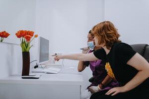 In a modern dental office, a dentist and a young patient engage in a collaborative consultation, exploring new tooth shades and discussing treatment options using a computer photo