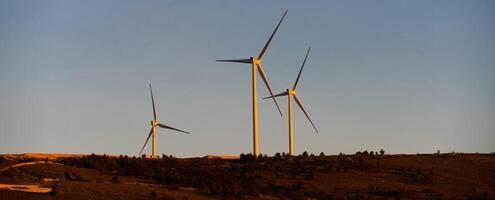 . A striking vista of modern wind turbines, stationed amidst the mountainous terrain, exemplifying the concept of conservation and harnessing natural energy resources photo