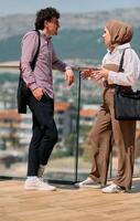 After a day at the office, a business man engages in conversation with his Muslim colleague wearing a hijab photo
