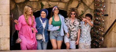 A diverse group of tourists, dressed in summer attire, strolls through the tourist city with wide smiles, enjoying their sightseeing adventure photo