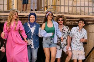 A diverse group of tourists, dressed in summer attire, strolls through the tourist city with wide smiles, enjoying their sightseeing adventure photo