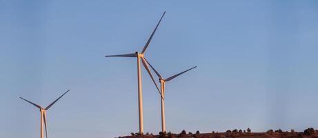 A striking vista of modern wind turbines, stationed amidst the mountainous terrain, exemplifying the concept of conservation and harnessing natural energy resources photo