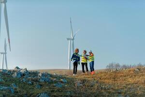 A team of engineers and workers oversees a wind turbine project at a modern wind farm, working together to ensure the efficient generation of renewable energy photo