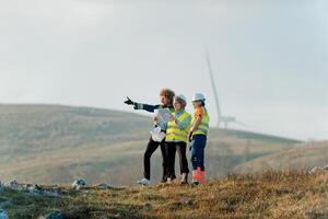 A team of engineers and workers oversees a wind turbine project at a modern wind farm, working together to ensure the efficient generation of renewable energy photo