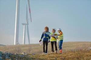A team of engineers and workers oversees a wind turbine project at a modern wind farm, working together to ensure the efficient generation of renewable energy photo