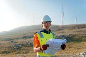 An engineer holding a paper project of a wind turbine for electricity production. photo