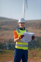 An engineer holding a paper project of a wind turbine for electricity production. photo