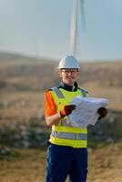 An engineer holding a paper project of a wind turbine for electricity production. photo