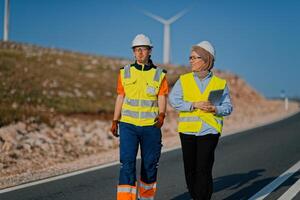 A team of engineers and workers oversees a wind turbine project at a modern wind farm, working together to ensure the efficient generation of renewable energy photo