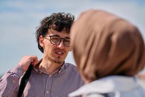 After a day at the office, a business man engages in conversation with his Muslim colleague wearing a hijab photo
