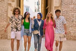 A diverse group of tourists, dressed in summer attire, strolls through the tourist city with wide smiles, enjoying their sightseeing adventure photo