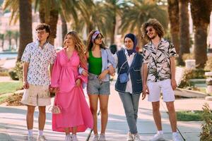 A diverse group of tourists, dressed in summer attire, strolls through the tourist city with wide smiles, enjoying their sightseeing adventure photo