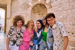 A diverse group of tourists, dressed in summer attire, strolls through the tourist city with wide smiles, enjoying their sightseeing adventure photo