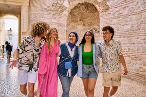 A diverse group of tourists, dressed in summer attire, strolls through the tourist city with wide smiles, enjoying their sightseeing adventure photo