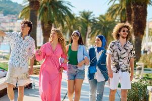 A diverse group of tourists, dressed in summer attire, strolls through the tourist city with wide smiles, enjoying their sightseeing adventure photo