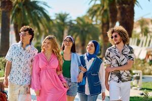 A diverse group of tourists, dressed in summer attire, strolls through the tourist city with wide smiles, enjoying their sightseeing adventure photo