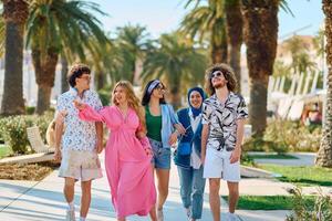 A diverse group of tourists, dressed in summer attire, strolls through the tourist city with wide smiles, enjoying their sightseeing adventure photo
