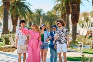 A diverse group of tourists, dressed in summer attire, strolls through the tourist city with wide smiles, enjoying their sightseeing adventure photo