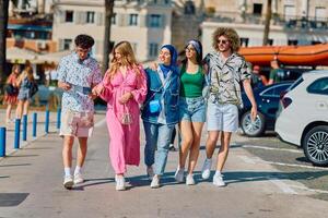A diverse group of tourists, dressed in summer attire, strolls through the tourist city with wide smiles, enjoying their sightseeing adventure photo