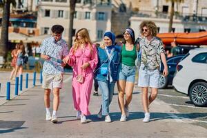 A diverse group of tourists, dressed in summer attire, strolls through the tourist city with wide smiles, enjoying their sightseeing adventure photo