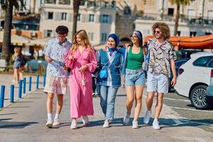 A diverse group of tourists, dressed in summer attire, strolls through the tourist city with wide smiles, enjoying their sightseeing adventure photo