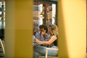 Young Business Duo Strategizing Over Coffee and Tablets photo